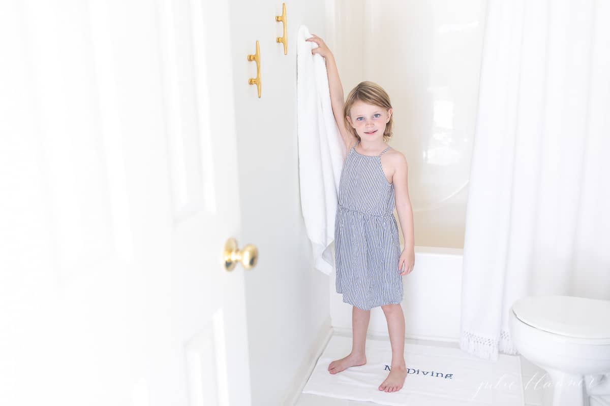 girl hanging white towel on brass boat cleat