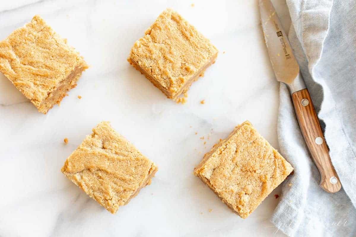 peanut butter brownies next to blue napkin and knife