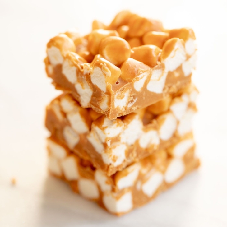A stack of butterscotch peanut butter marshmallow bars on a marble countertop.