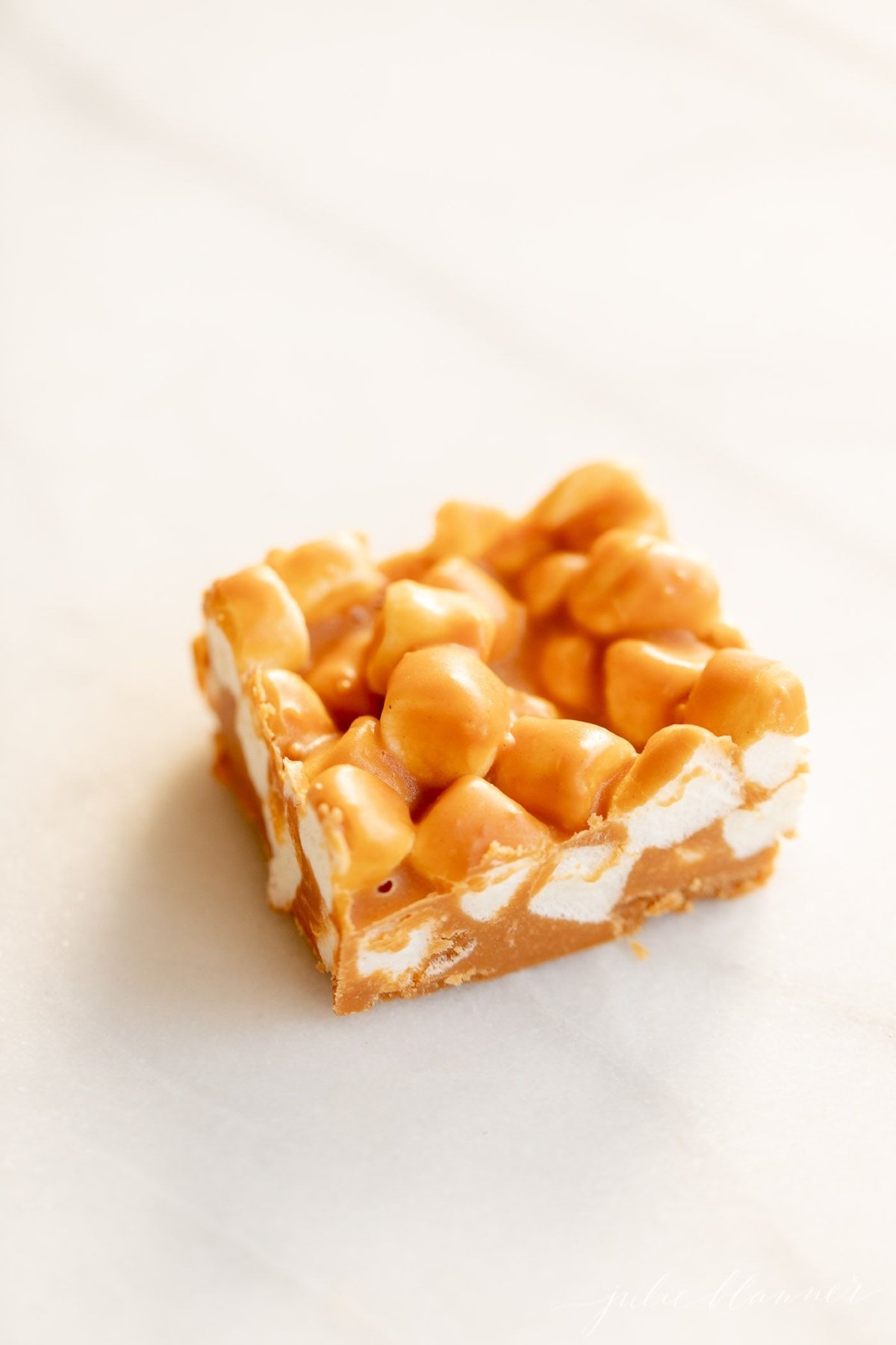 A butterscotch and marshmallow bar on a marble countertop.