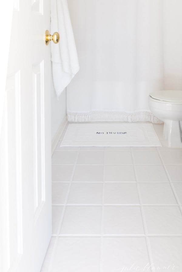 A bathroom with white tile with the grout lines refreshed with Polyblend Grout Renew.