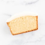 A slice of pound cake on a marble surface.