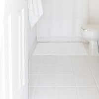 WHITE BATHROOM WITH WHITE TILE AND TILE GROUT