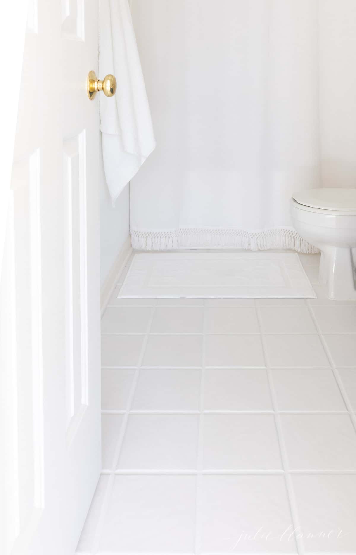 WHITE BATHROOM WITH WHITE TILE AND TILE GROUT