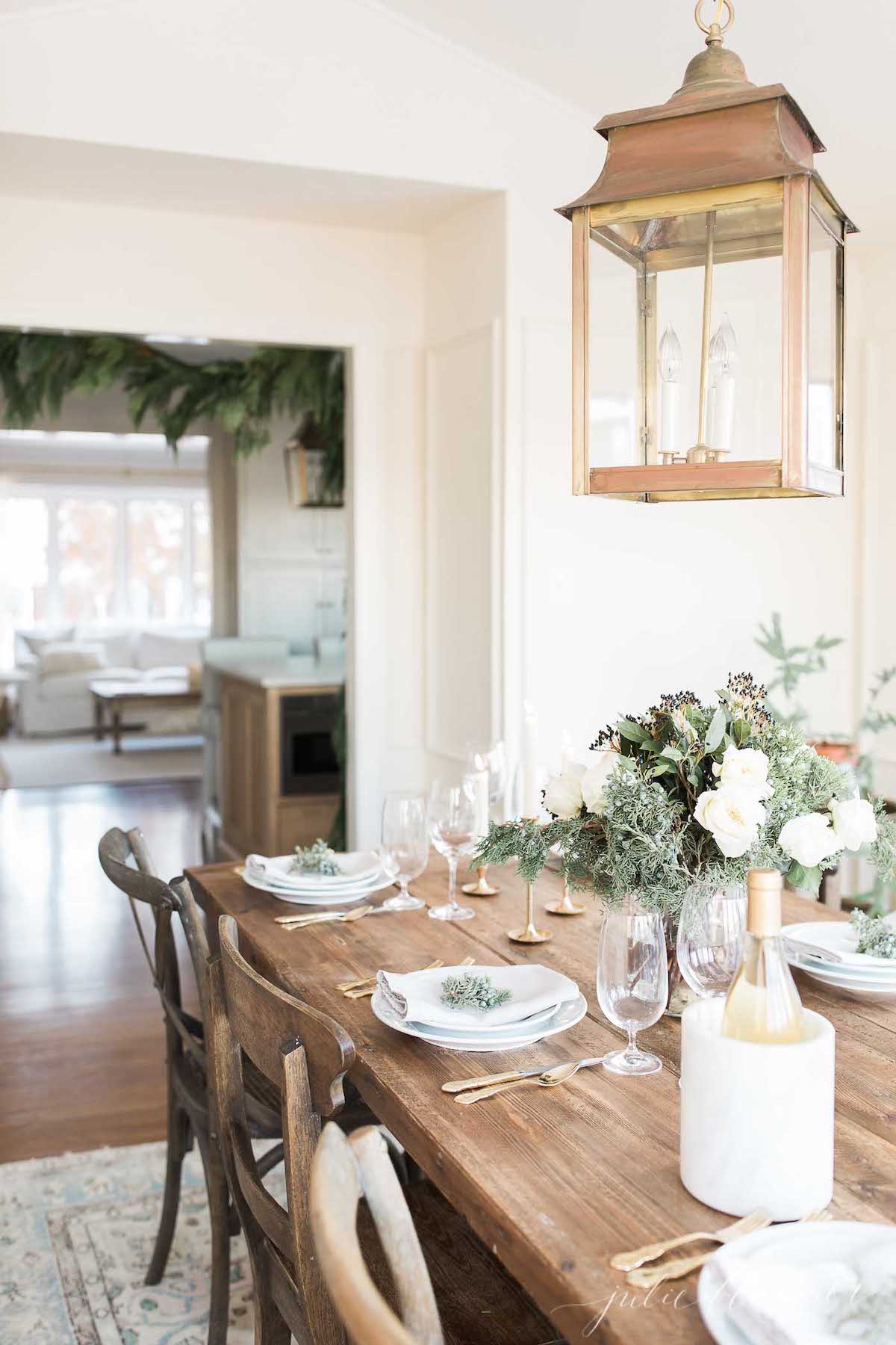 A dining room with a wooden table and greenery.