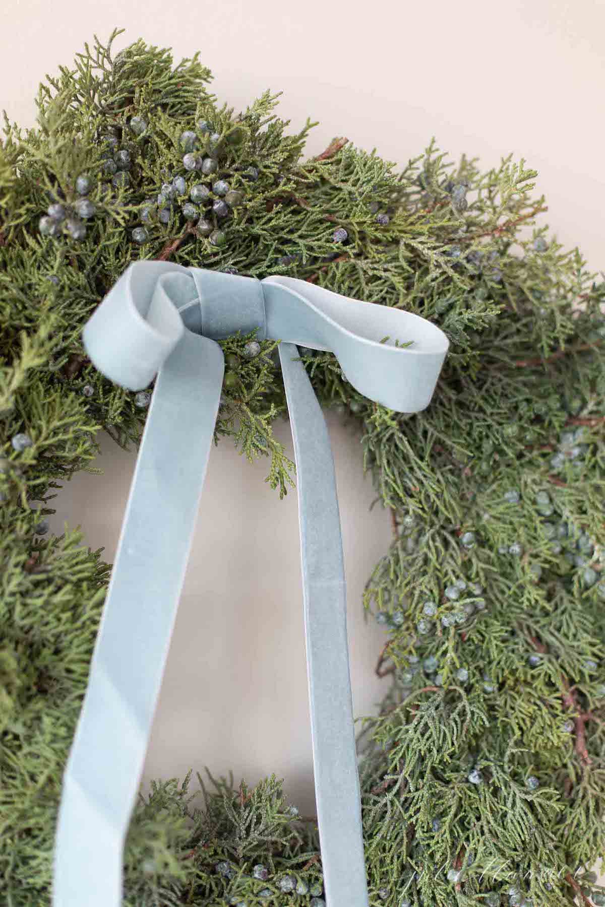 A beautiful wreath with a blue ribbon, perfect for holiday homes and adding festive blue Christmas decorations.