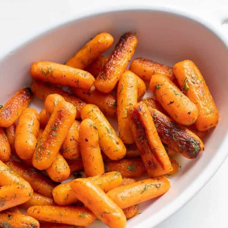 White oval serving platter with roasted dill carrots.