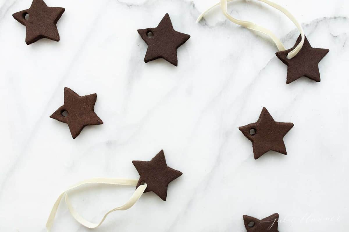 Cinnamon ornaments in the shape of stars on a marble surface.