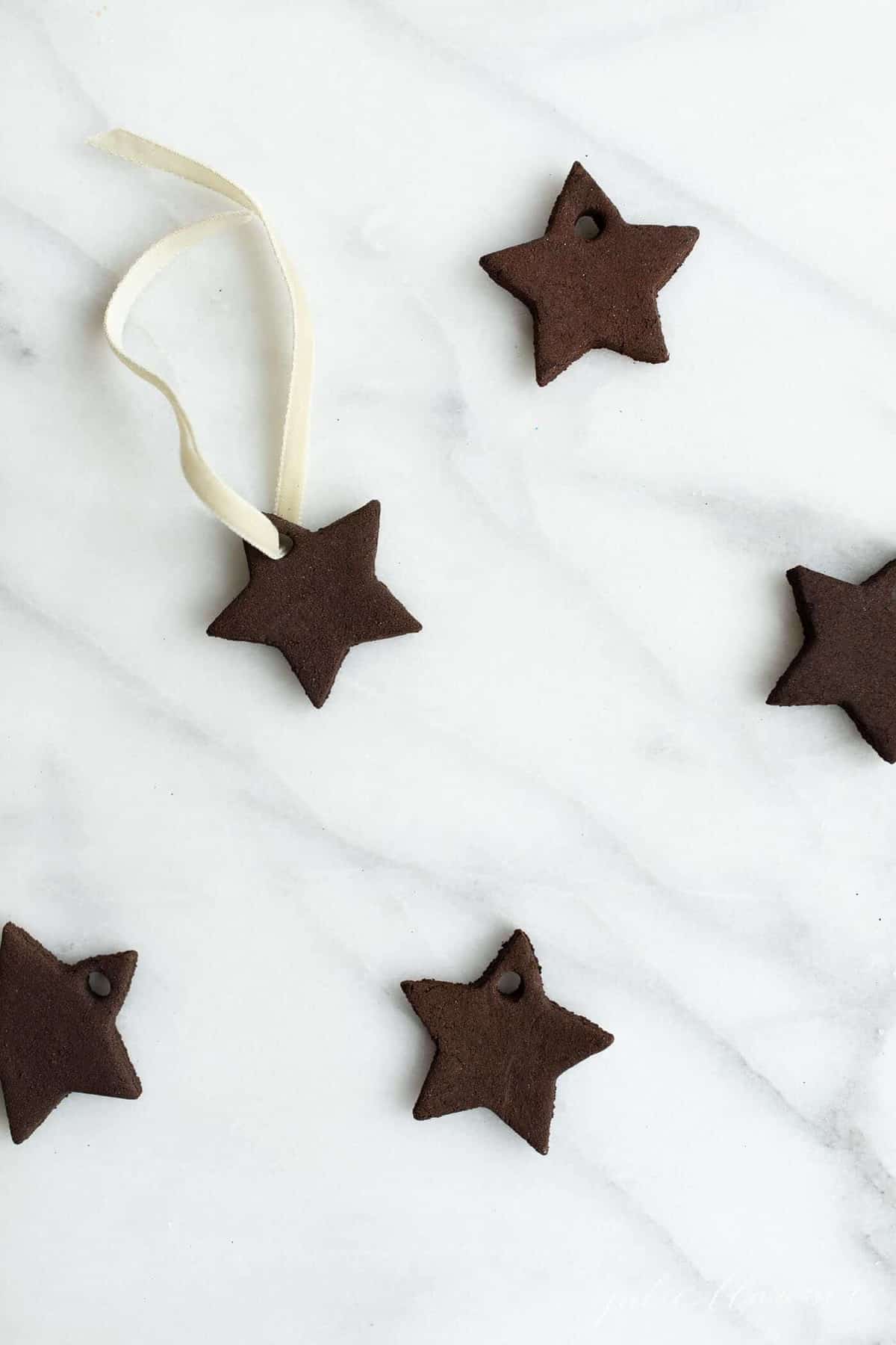 Cinnamon ornaments in the shape of stars on a marble surface.