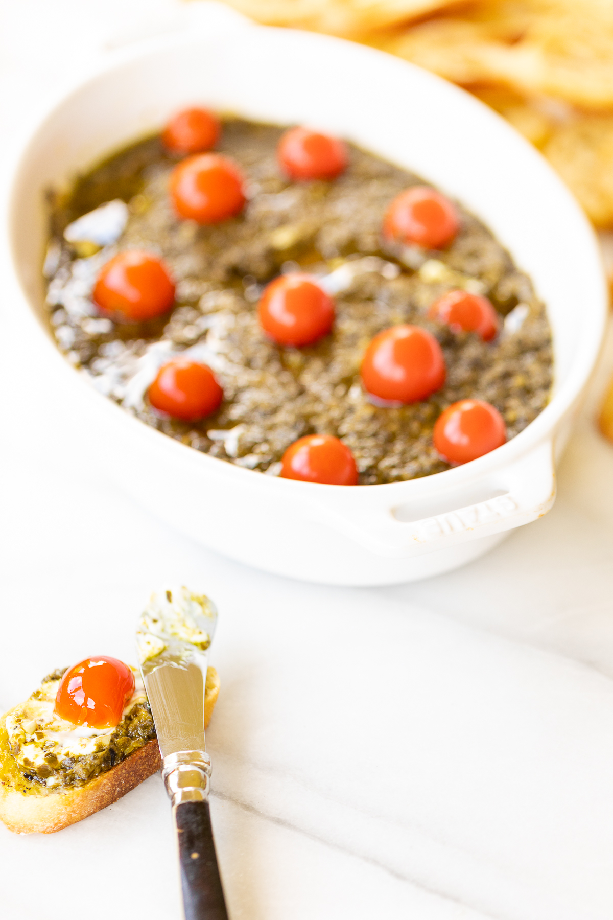 An easy appetizer dip with pesto cheese in a white bowl.