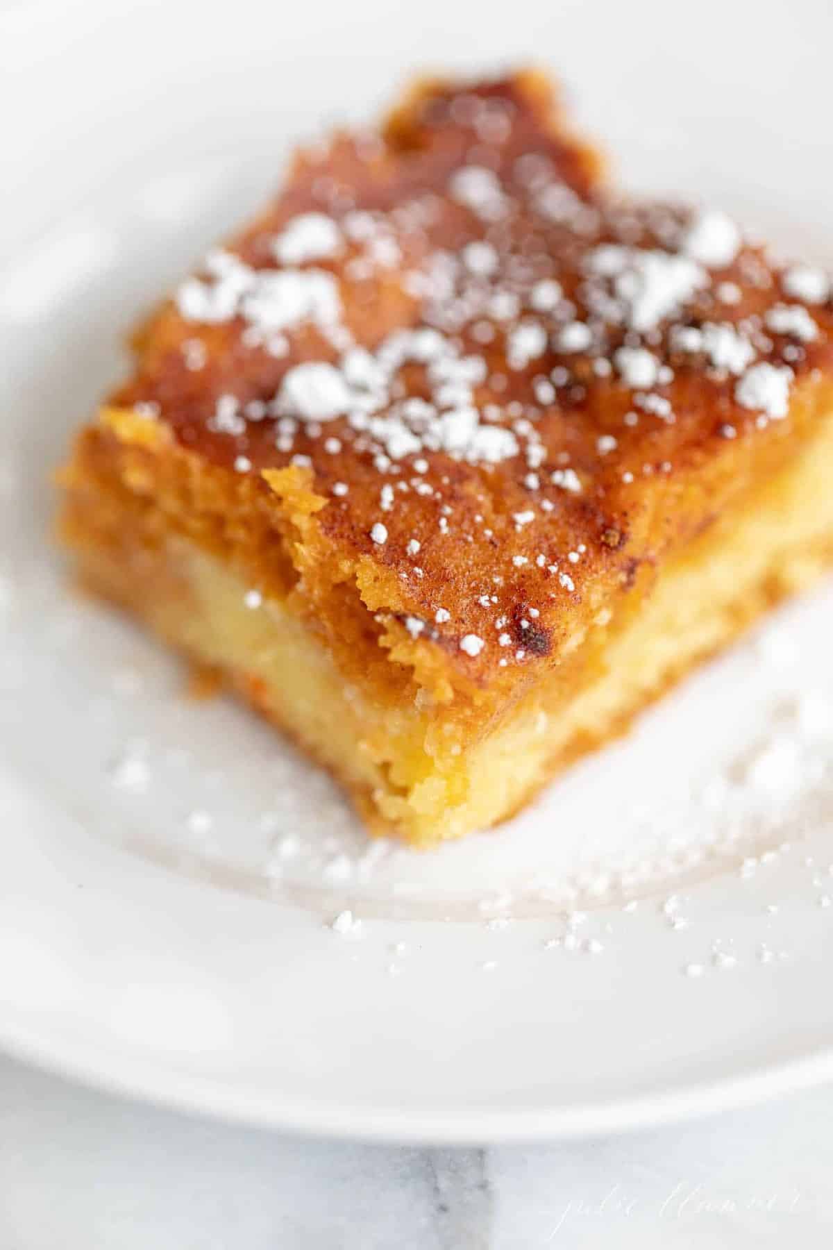 Small white plate with a single slice of gooey pumpkin butter cake.