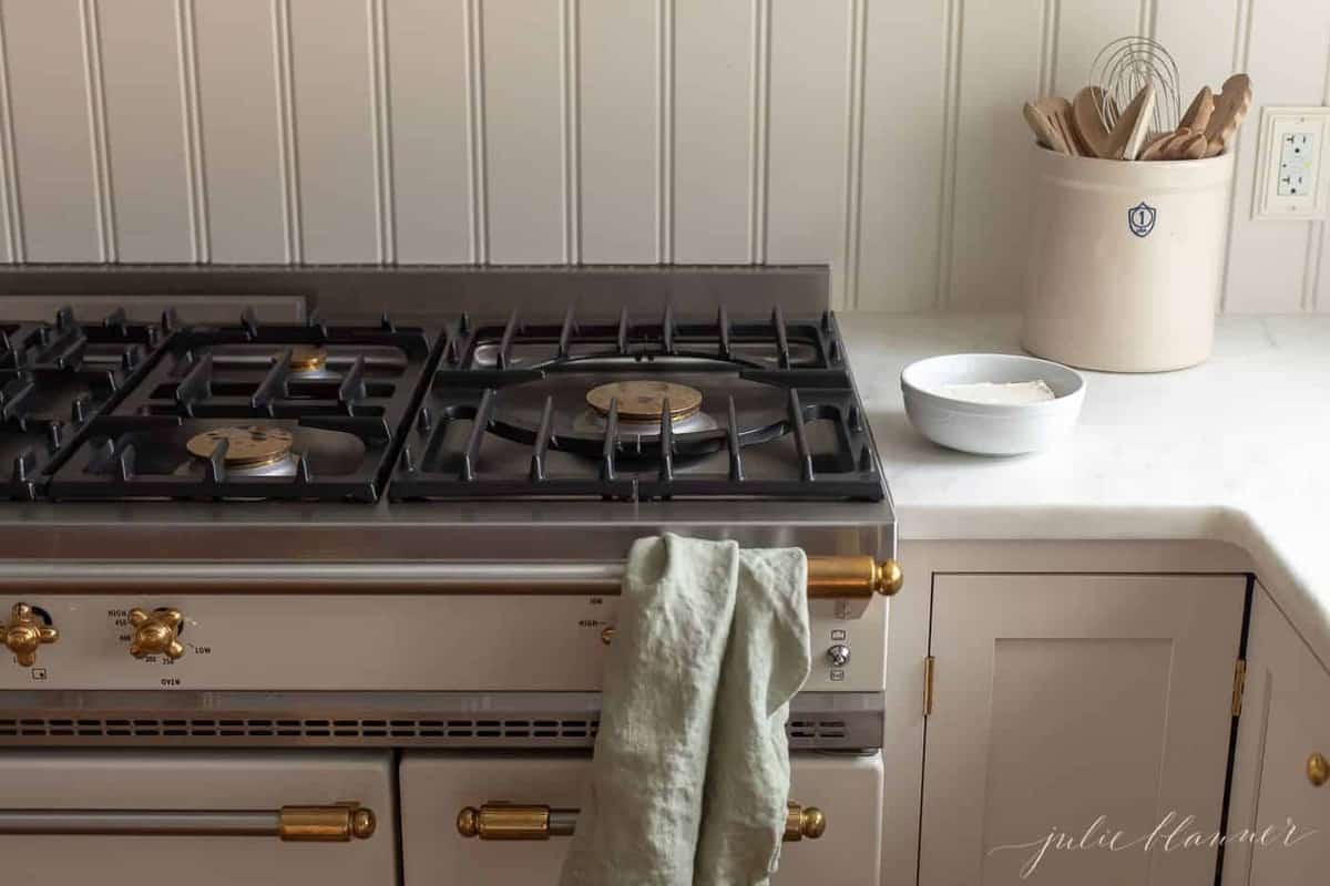 Ivory and brass range with a bowl of cream cheese on the counter beside it.