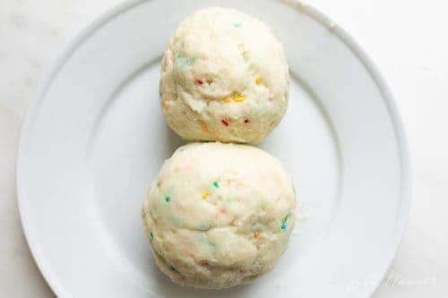 Two balls of funfetti cheeseballs for a snowman cheeseball dessert.