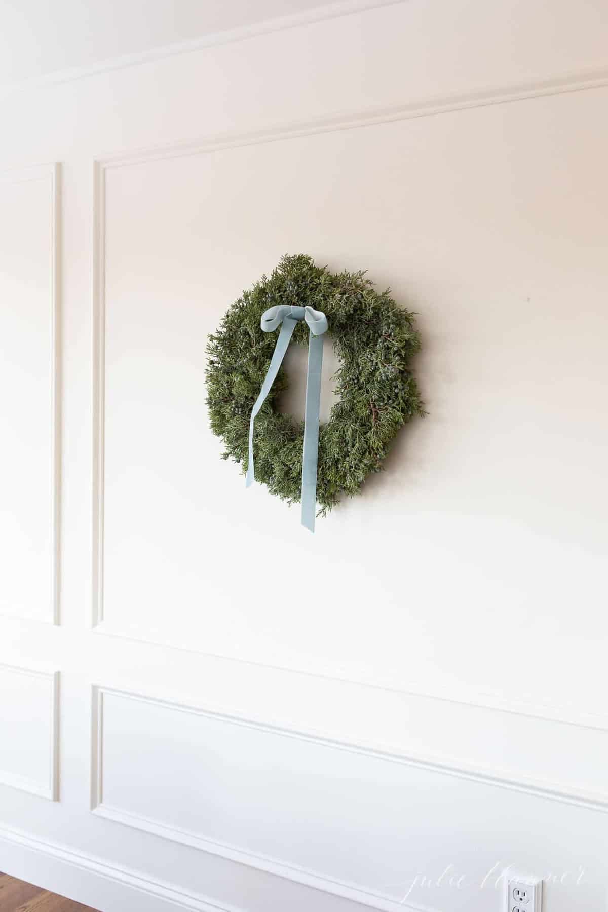 juniper wreath with blue velvet ribbon in cream breakfast nook