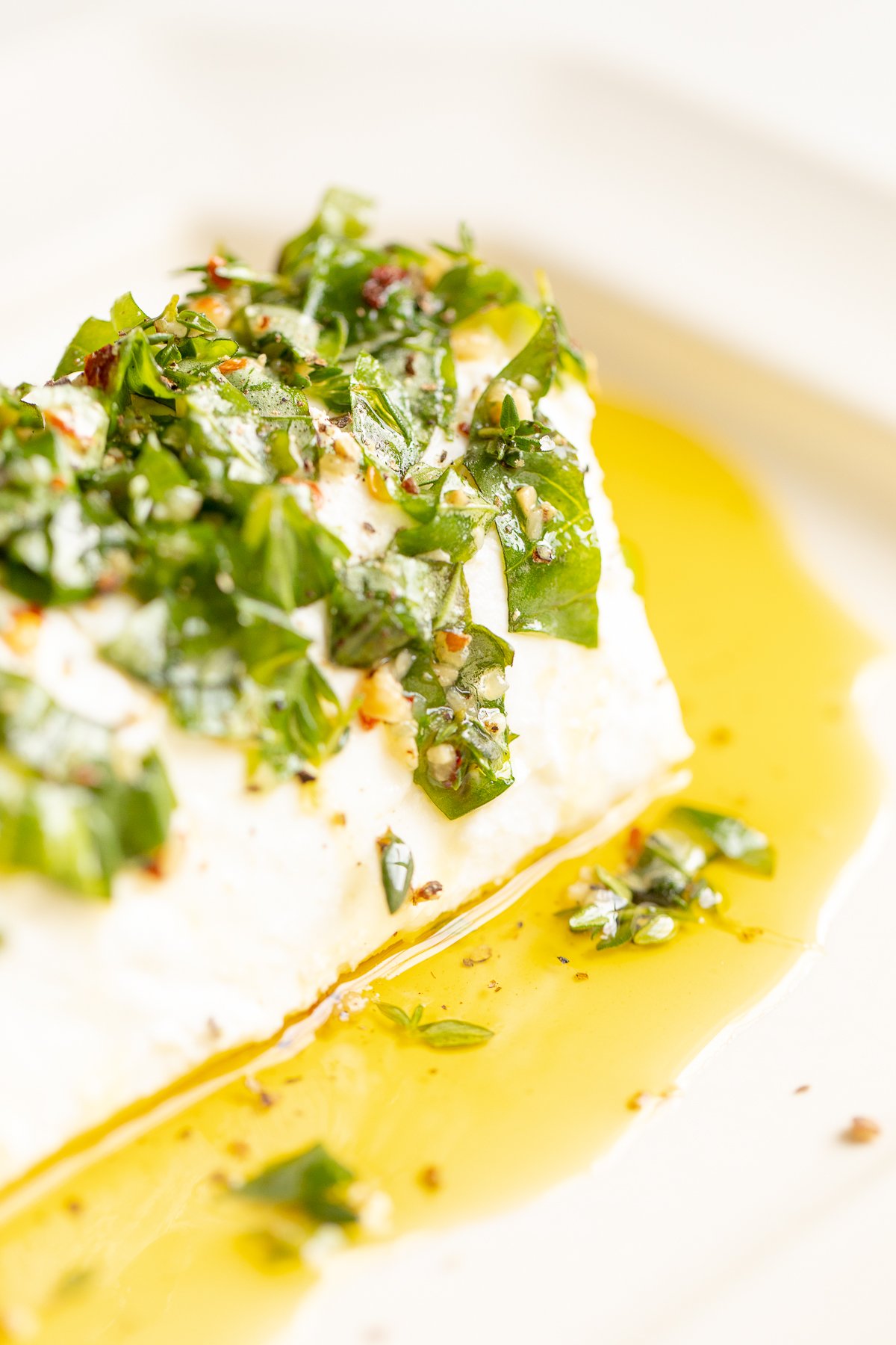 A white plate with a marinated goat cheese appetizer