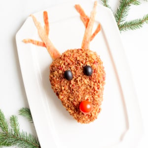 A plate with a reindeer head cheeseball on it.