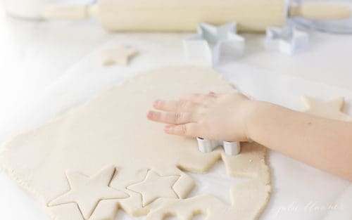 kid cutting out salt dough with cookie cutters