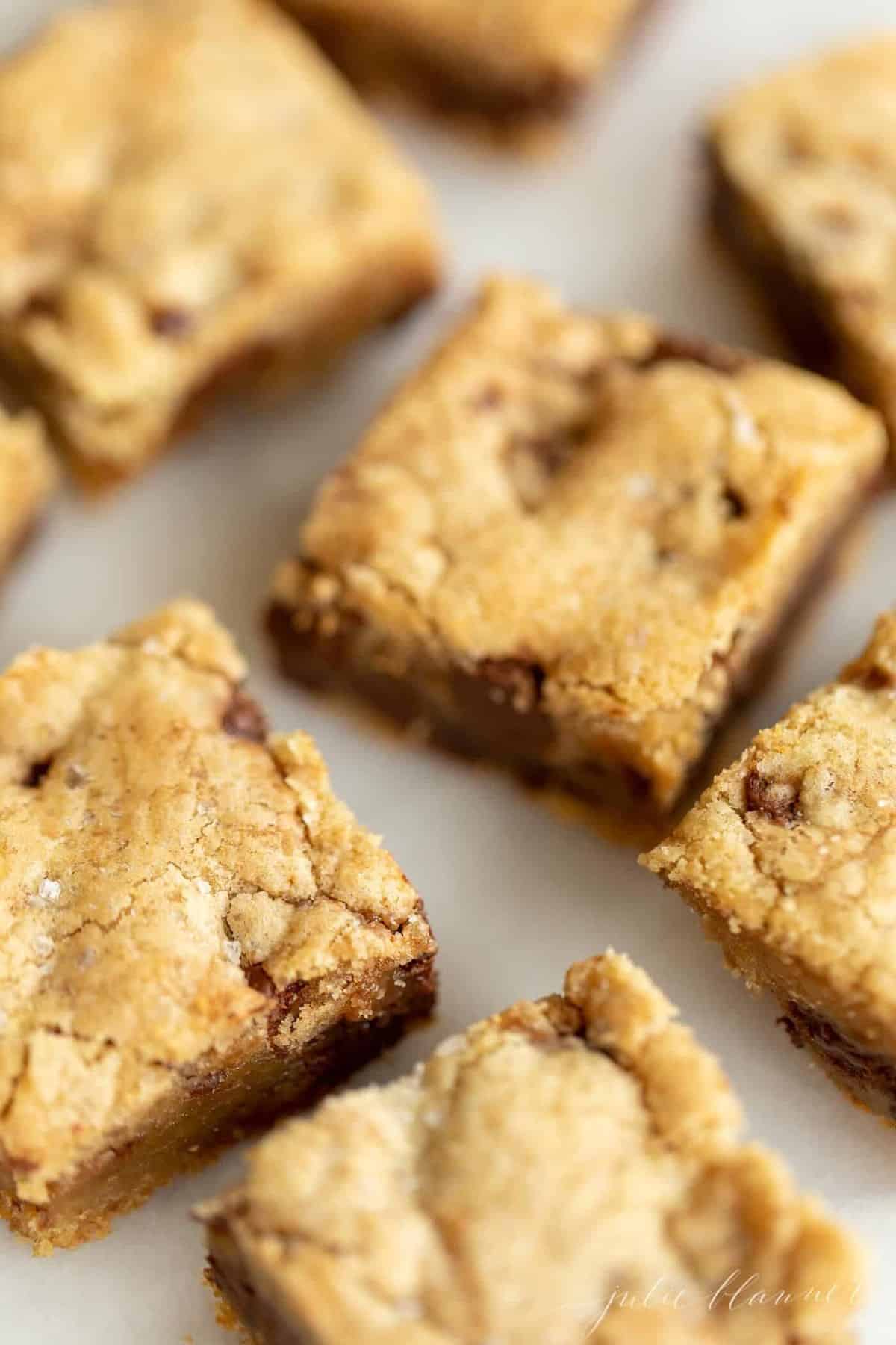 Salted Caramel Chocolate chip cookie bars sliced and placed on a marble surface.