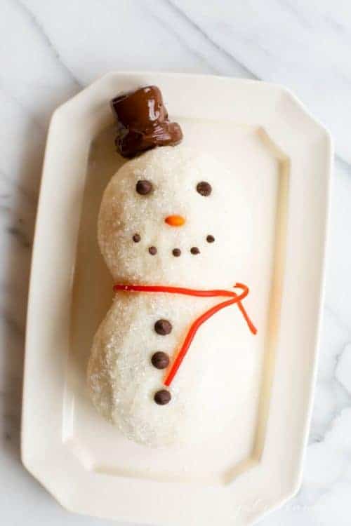 A cute Snowman dessert cheeseball on a white platter.