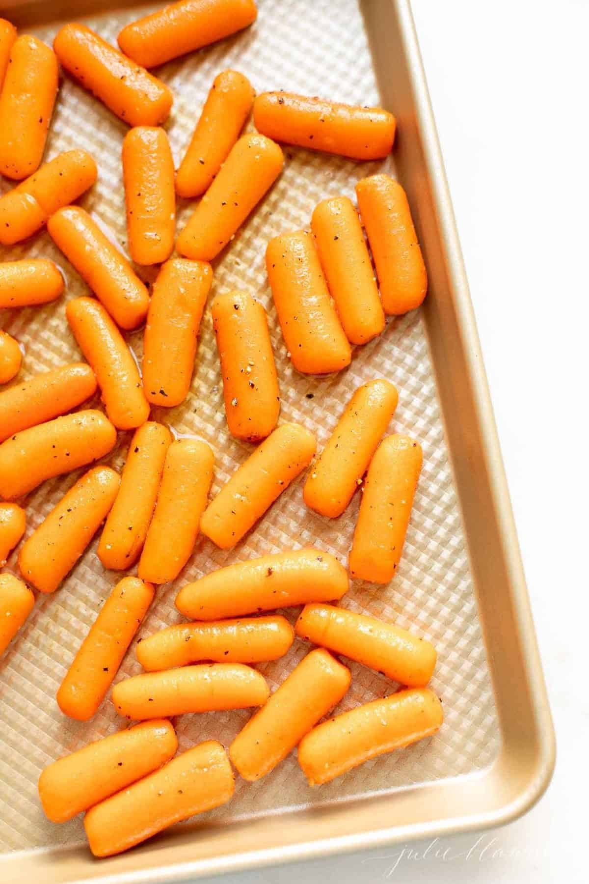 Gold pan filled with roasted baby carrots.