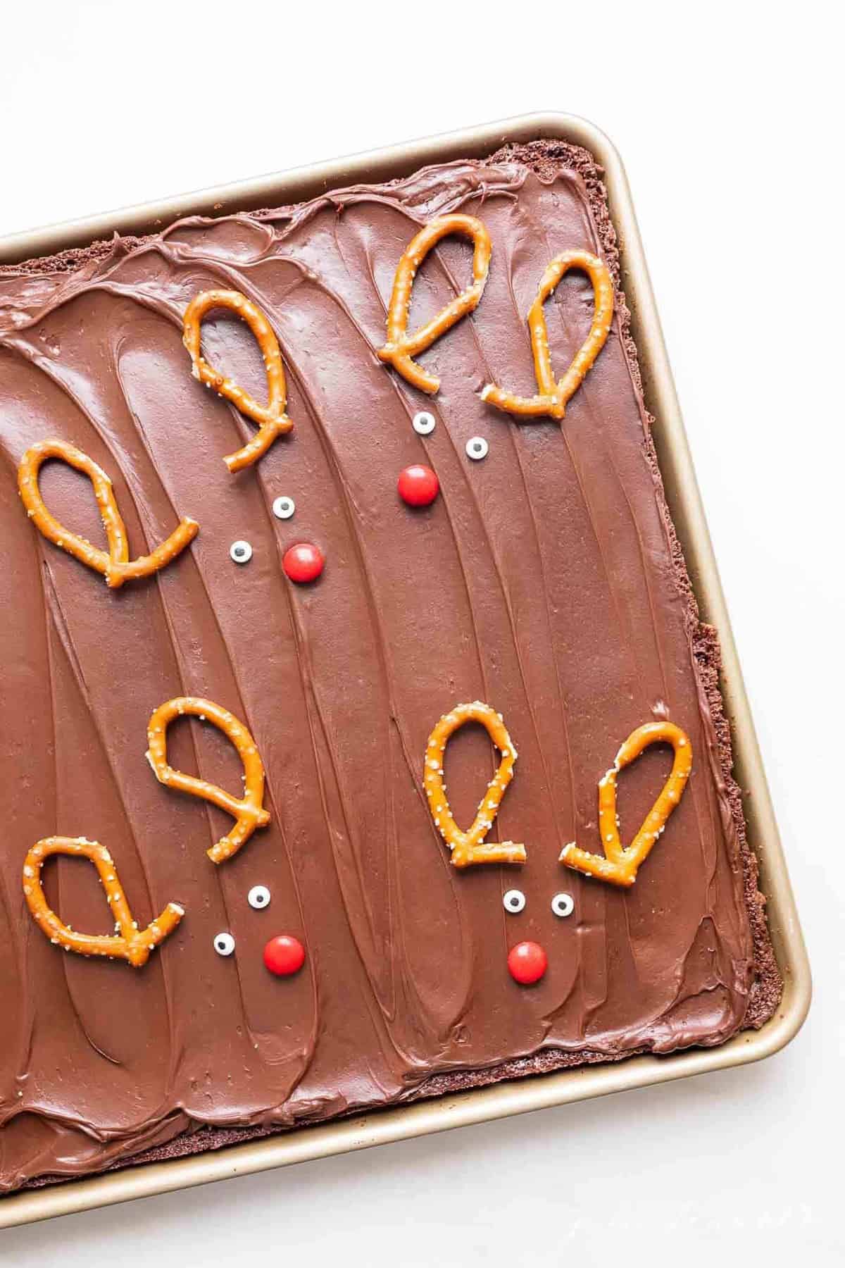 A pan of Christmas brownies decorated with reindeer pretzel antlers.