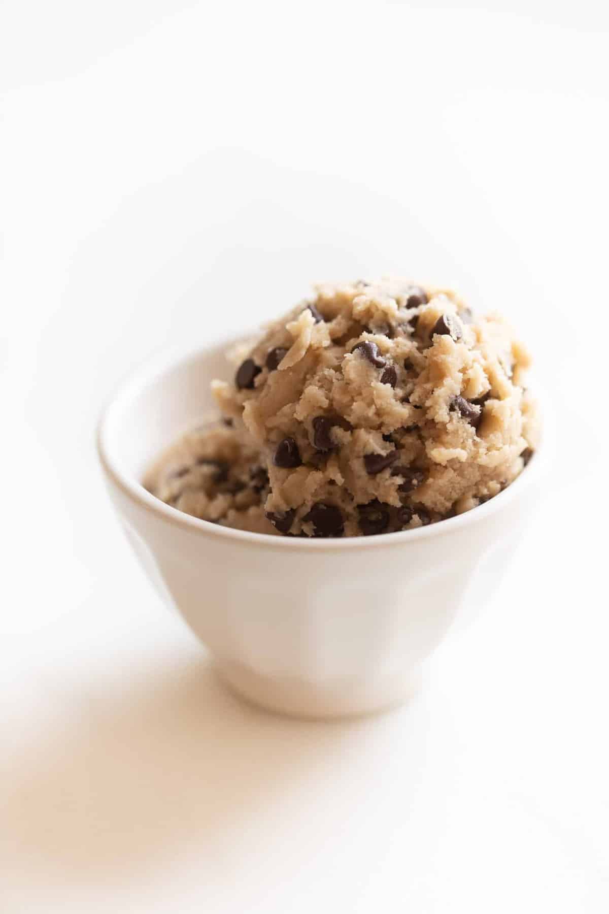 Two scoops of edible cookie dough in a white bowl