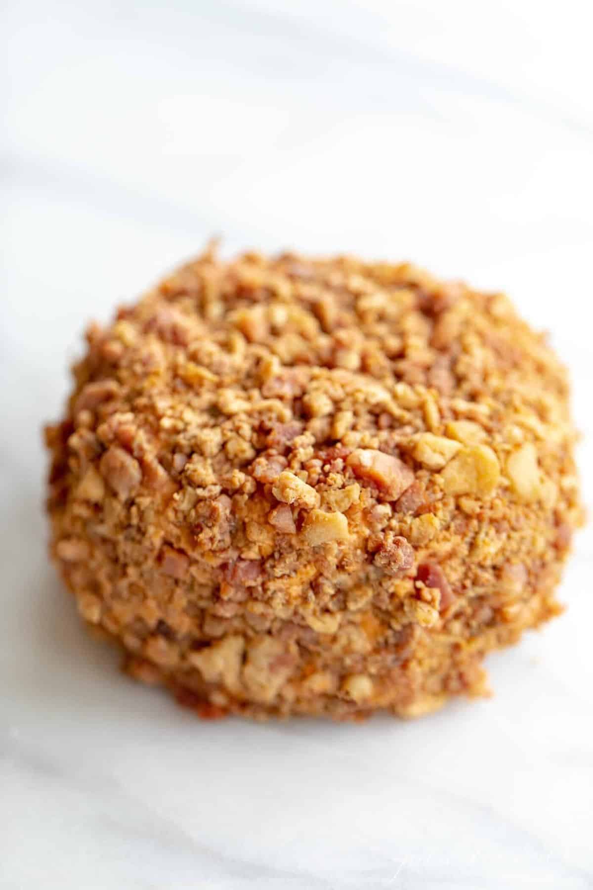 Marble counter top with a bacon covered cheese ball.