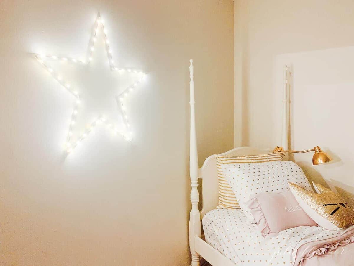 A bed in a room with light up star