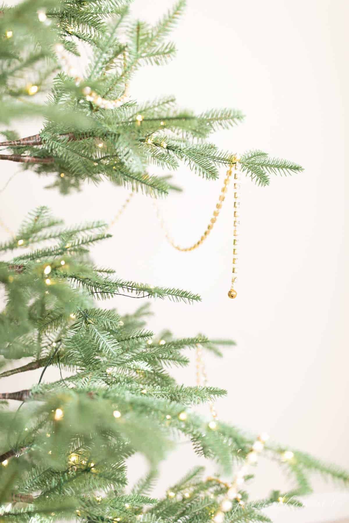 Close up shot of a Christmas tree draped with sparkling beaded garland.