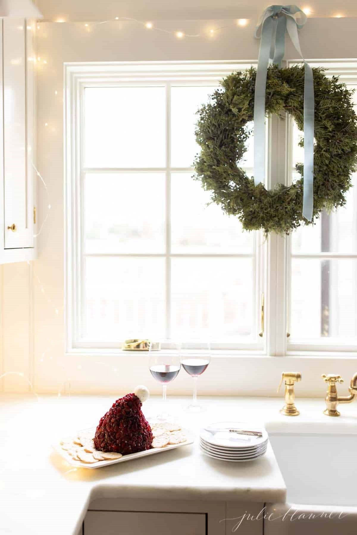 A cranberry cheese ball shaped into a santa hat in a kitchen