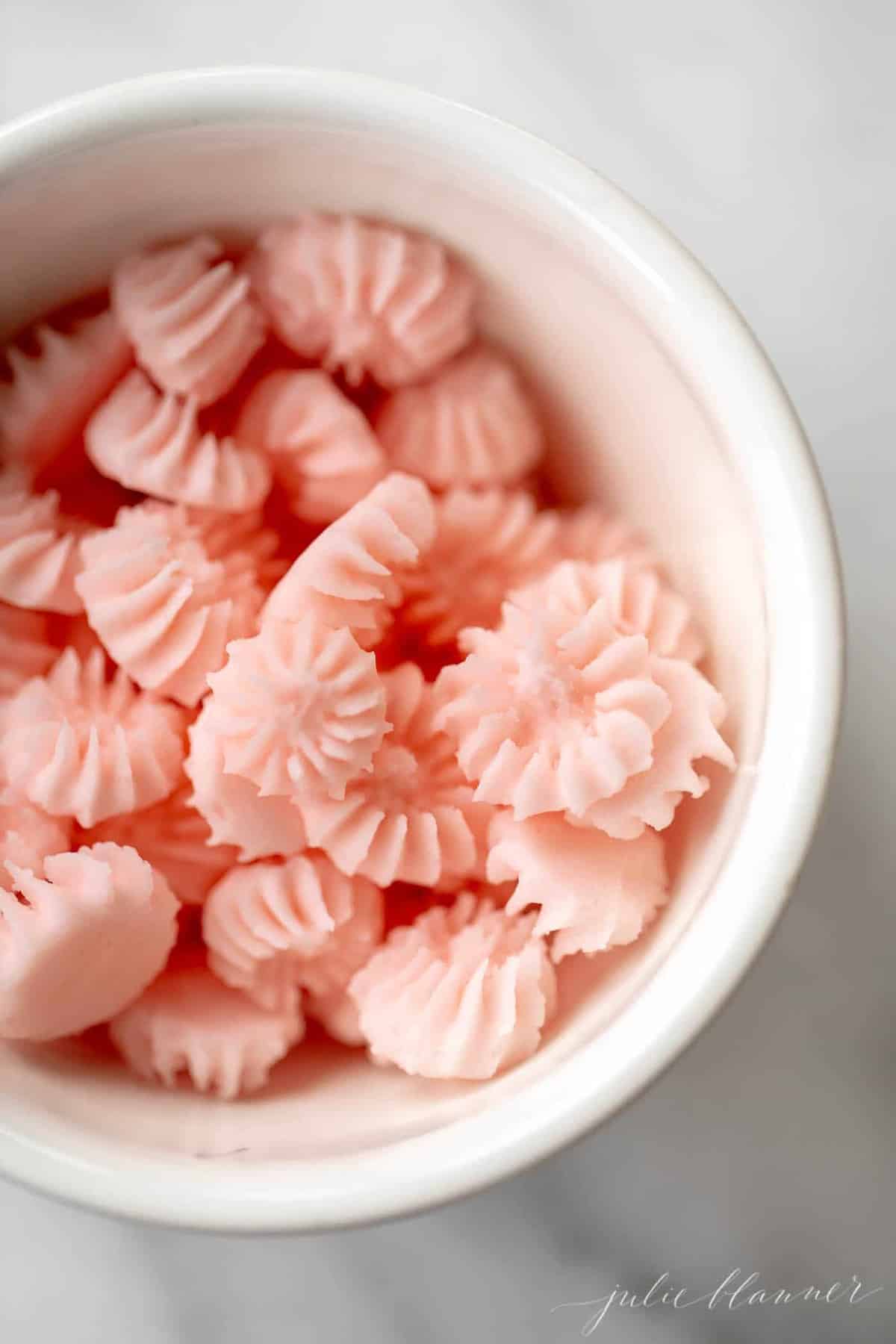 Top down shot of pink cream cheese mints in a bowl