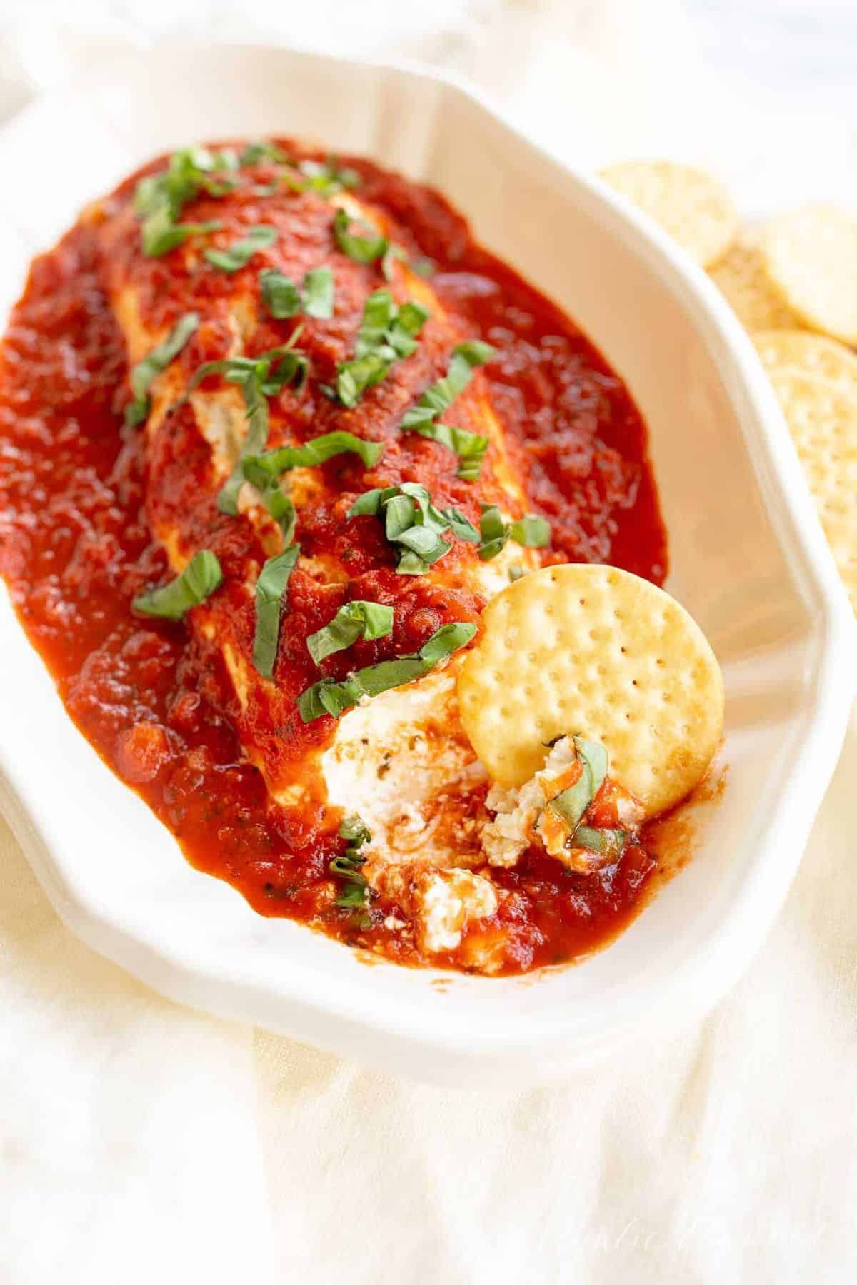 A white bowl filled with queso de cabra con tomate.