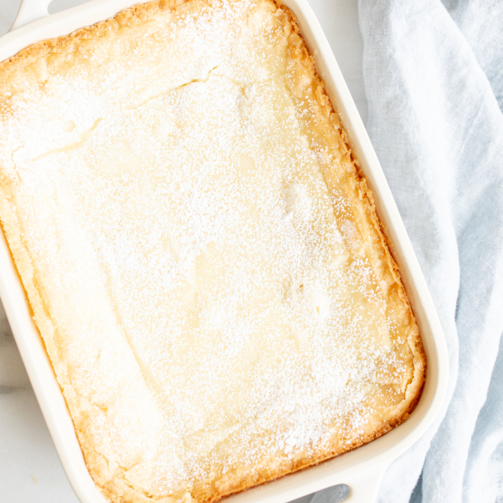 A white rectangular baking dish filled with a homemade gooey butter cake.