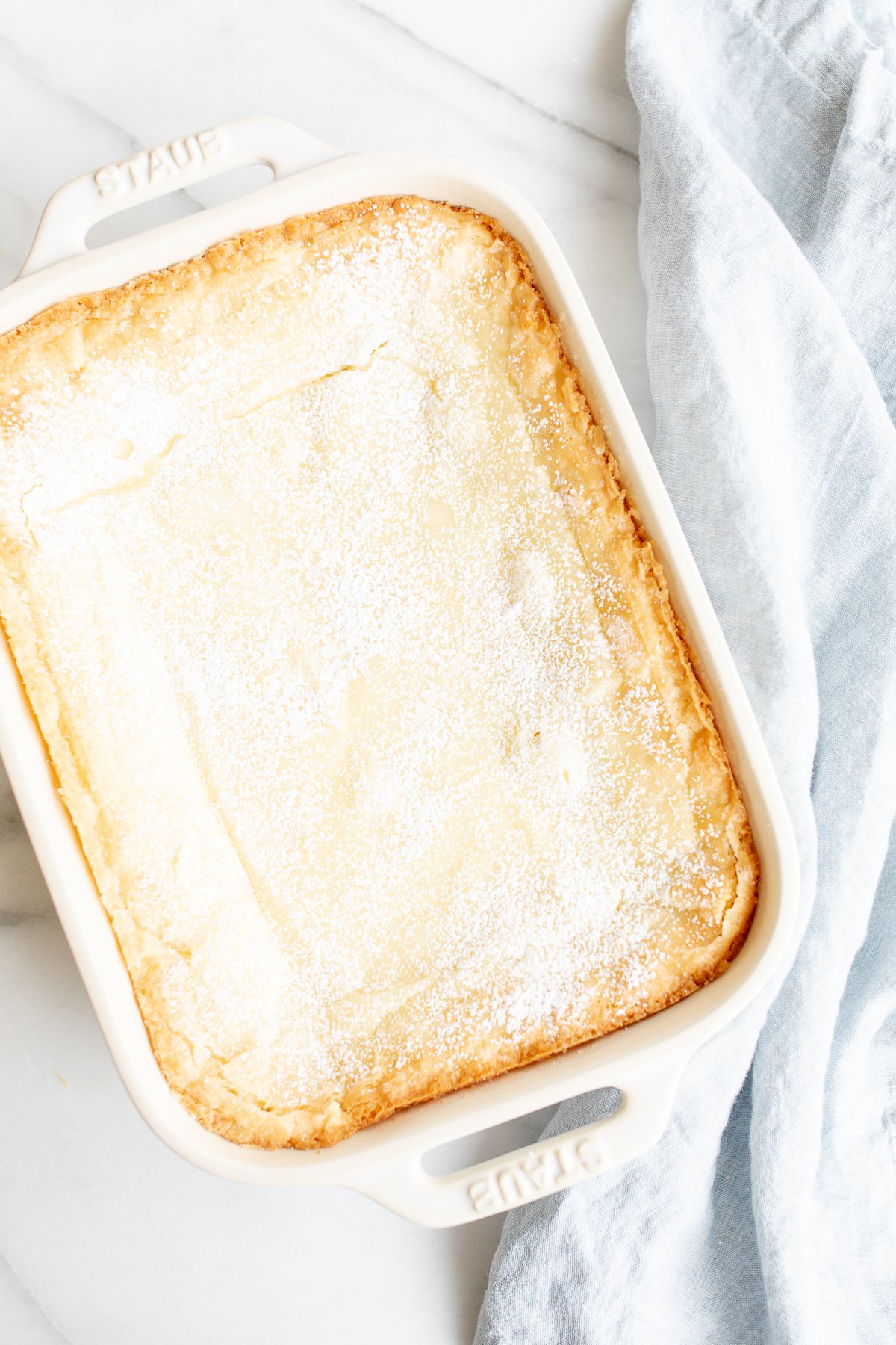 A white rectangular baking dish filled with a homemade gooey butter cake.