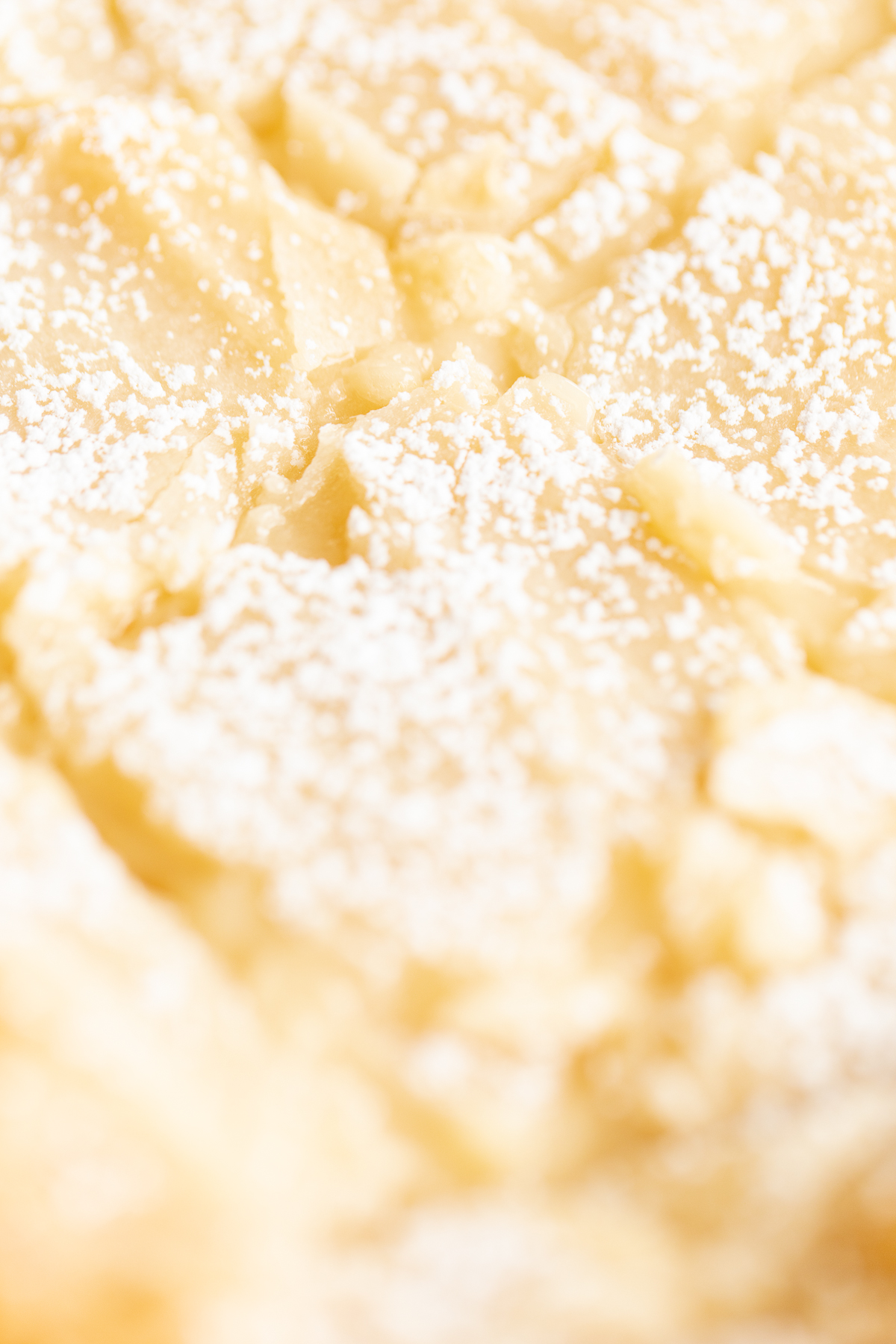 a close up of a gooey butter cake topped with powdered sugar