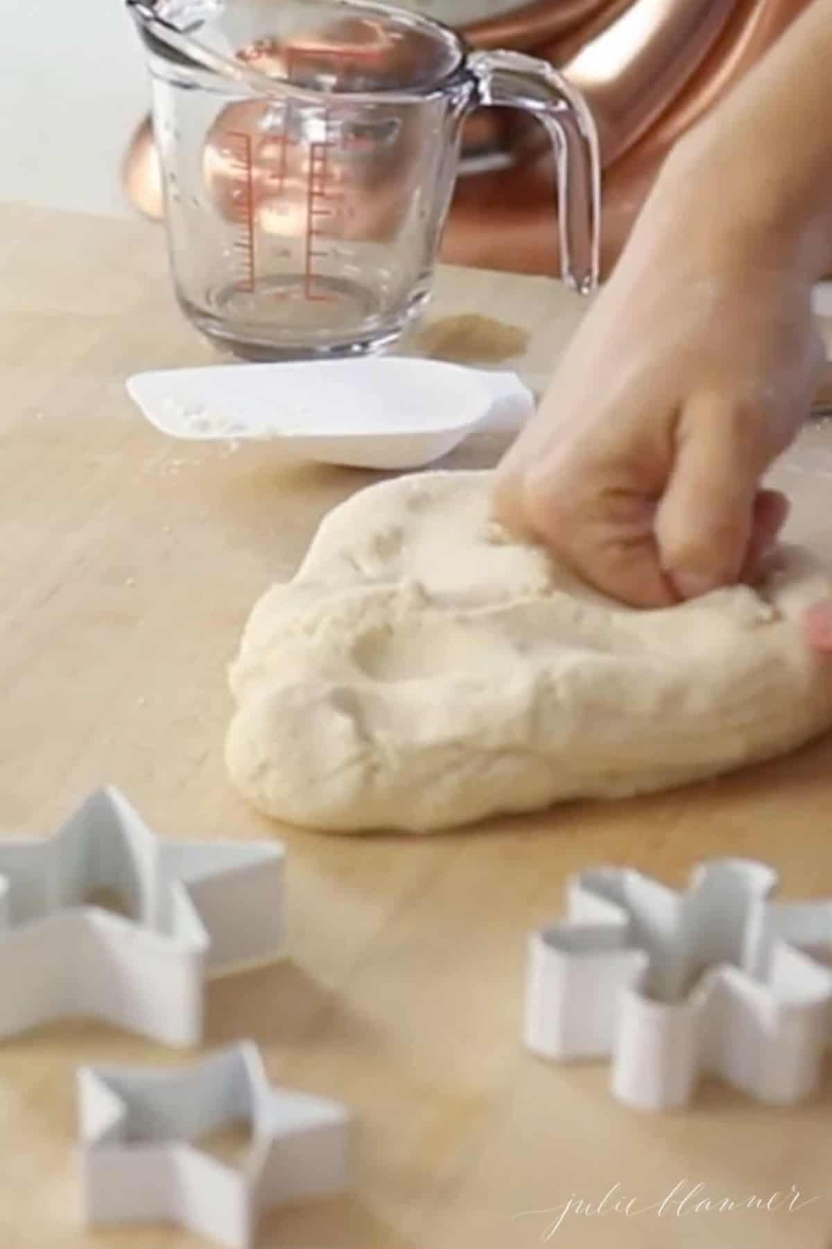 kneading salt dough next to cookie cutters