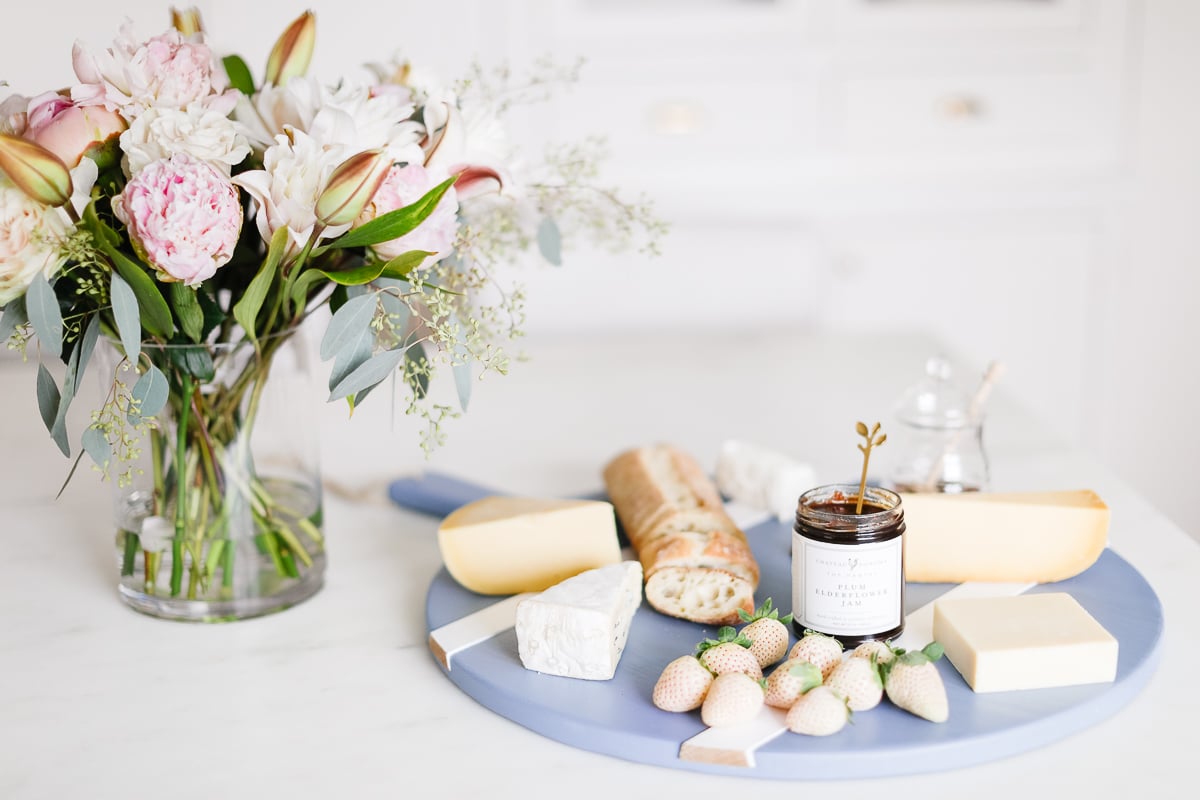 A blue cheeseboard with flowers in a hostess gift guide