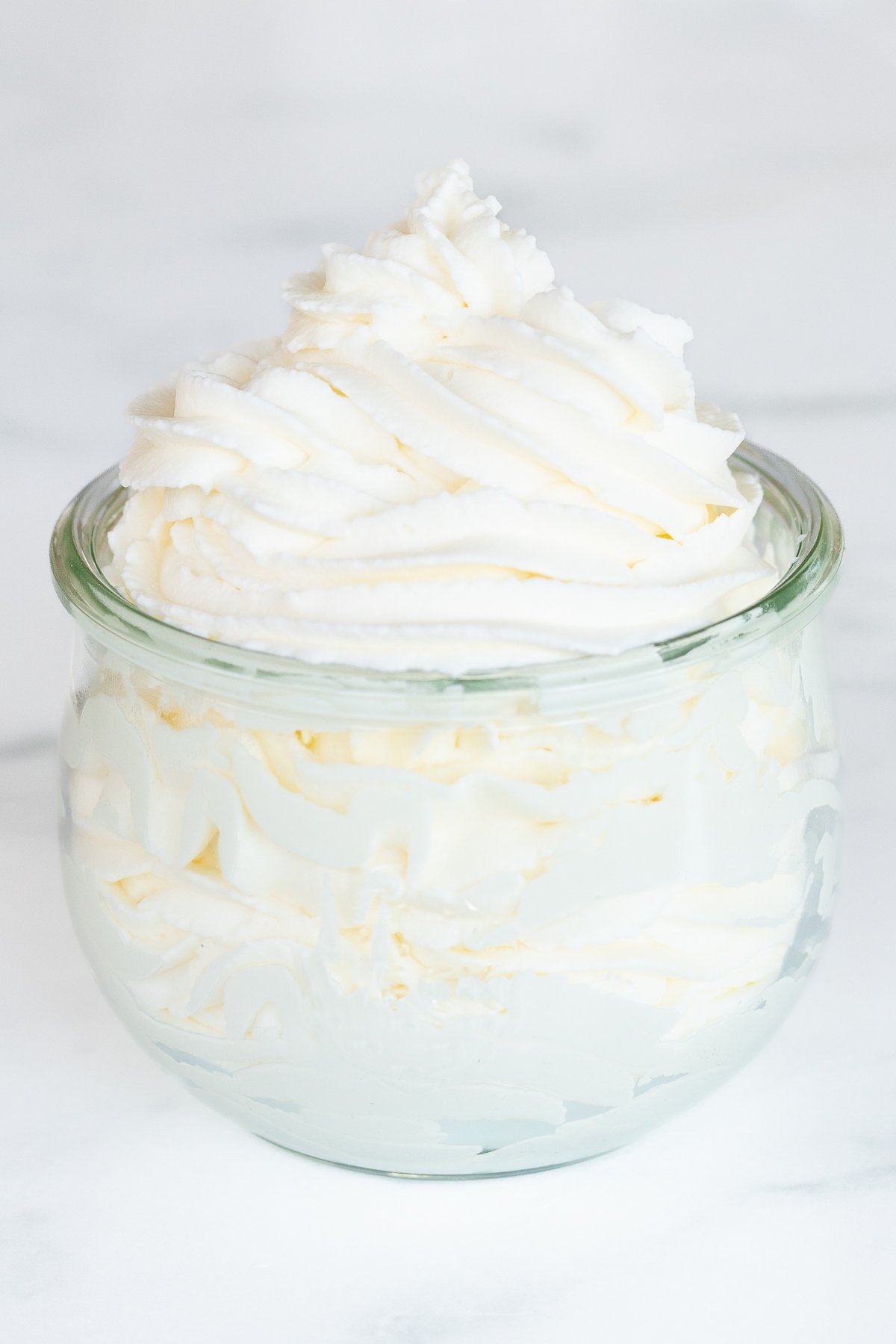 A small glass jar full of homemade whipped cream.