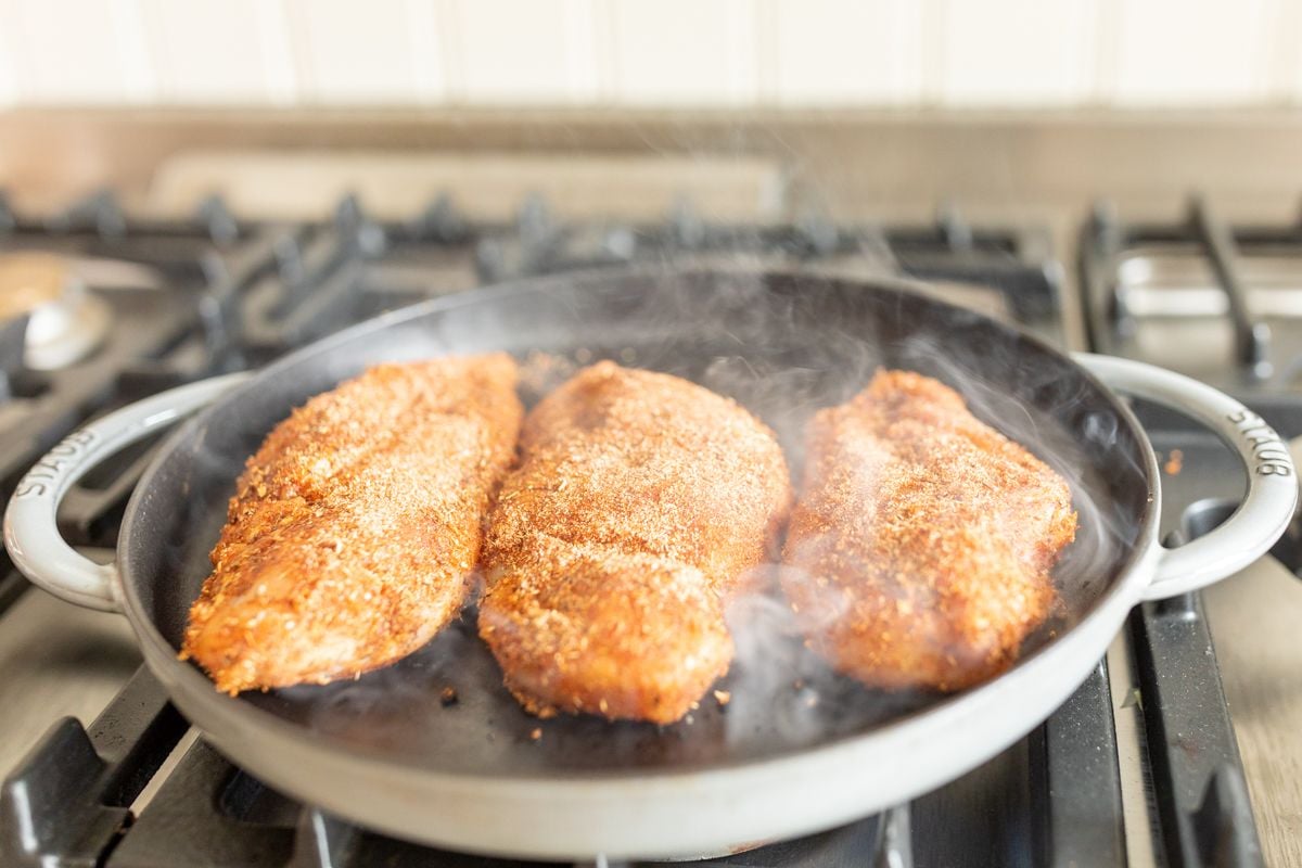 Blackened chicken breasts in a cast iron skillet