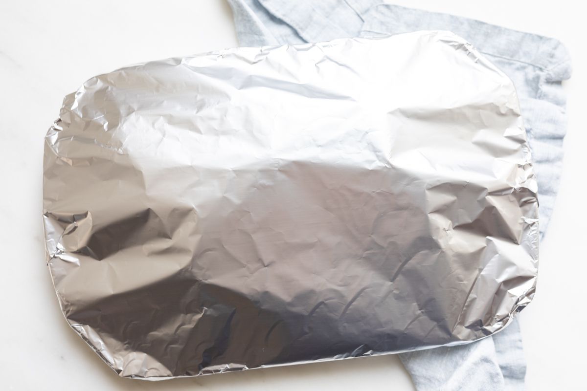 A serving platter wrapped in aluminum foil.
