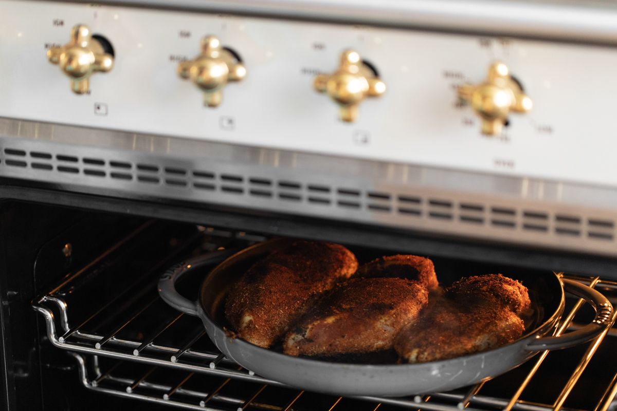 Blackened chicken breasts in a cast iron skillet in an oven