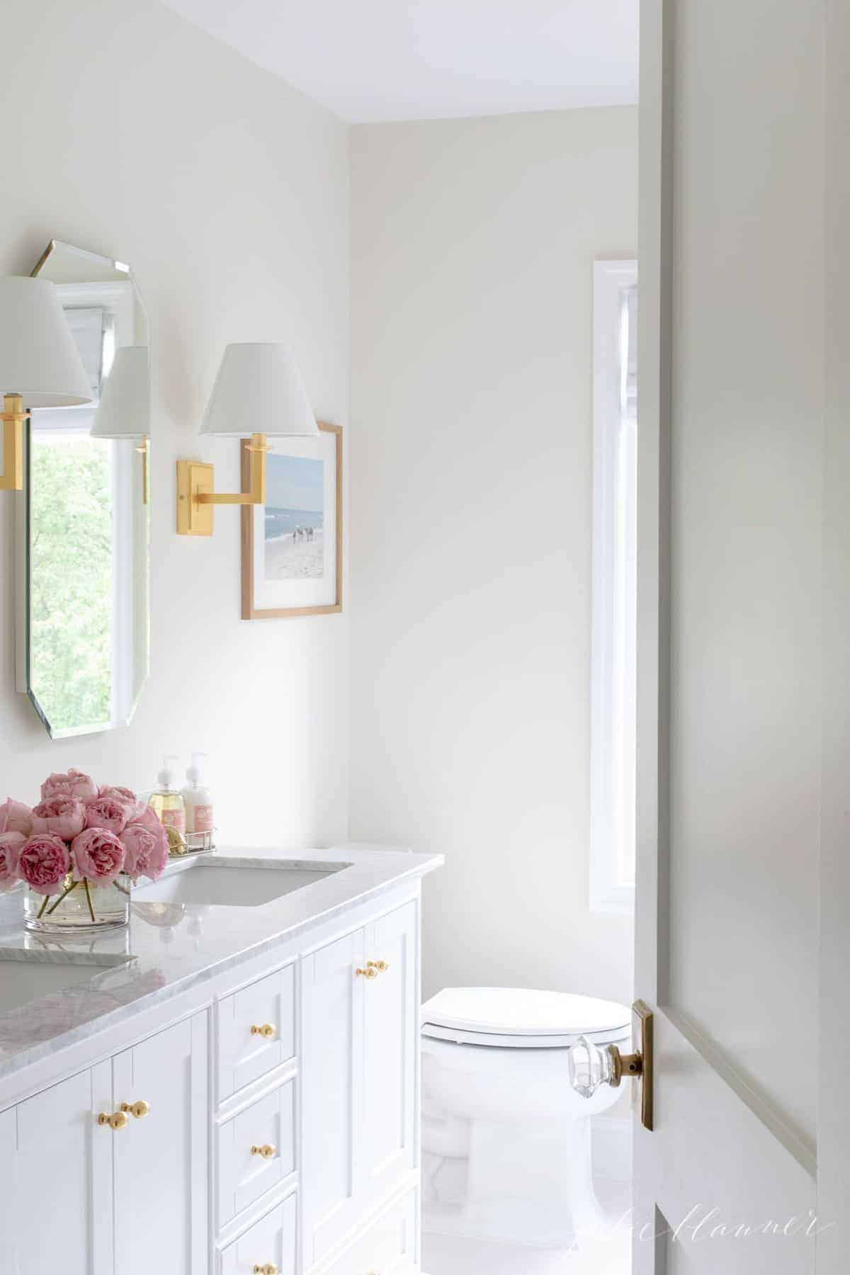 White bathroom with double vanity, white tile floor.