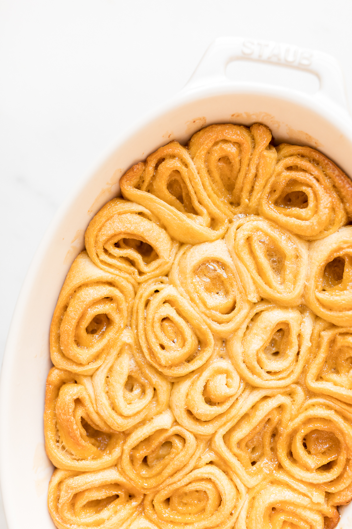 A white dish with easy caramel rolls in it.