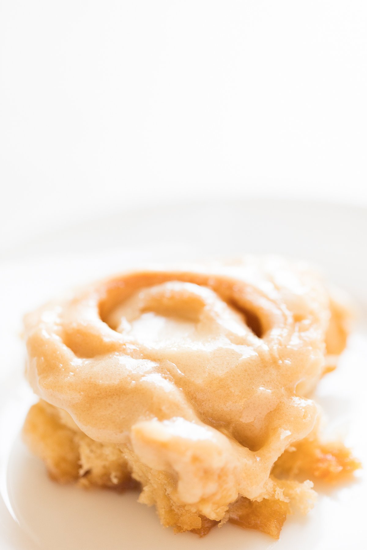 A piece of caramel roll on a white plate.