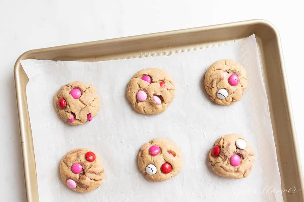 Gold baking sheet filled with Valentine's m and m cookies.