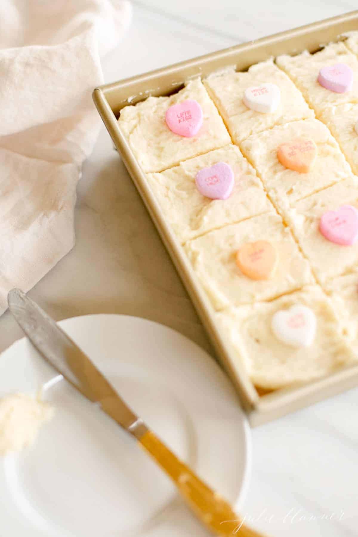 plate next to pan of frosted cookie bars