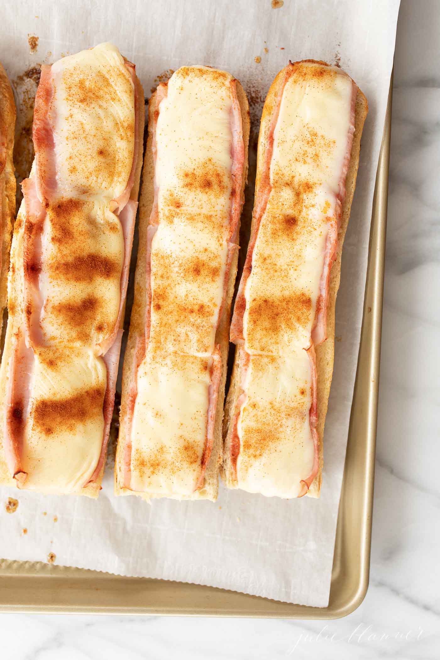 Gerber sandwiches on a parchment lined baking sheet.