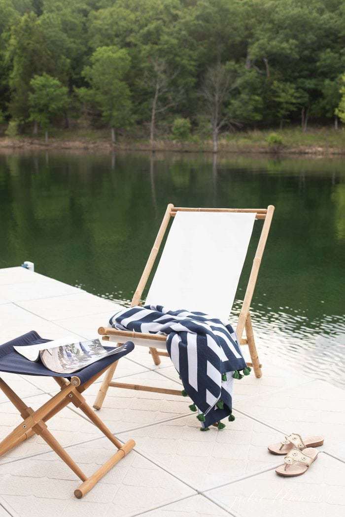 Lake with a single folding chair on the dock, towel draped across.