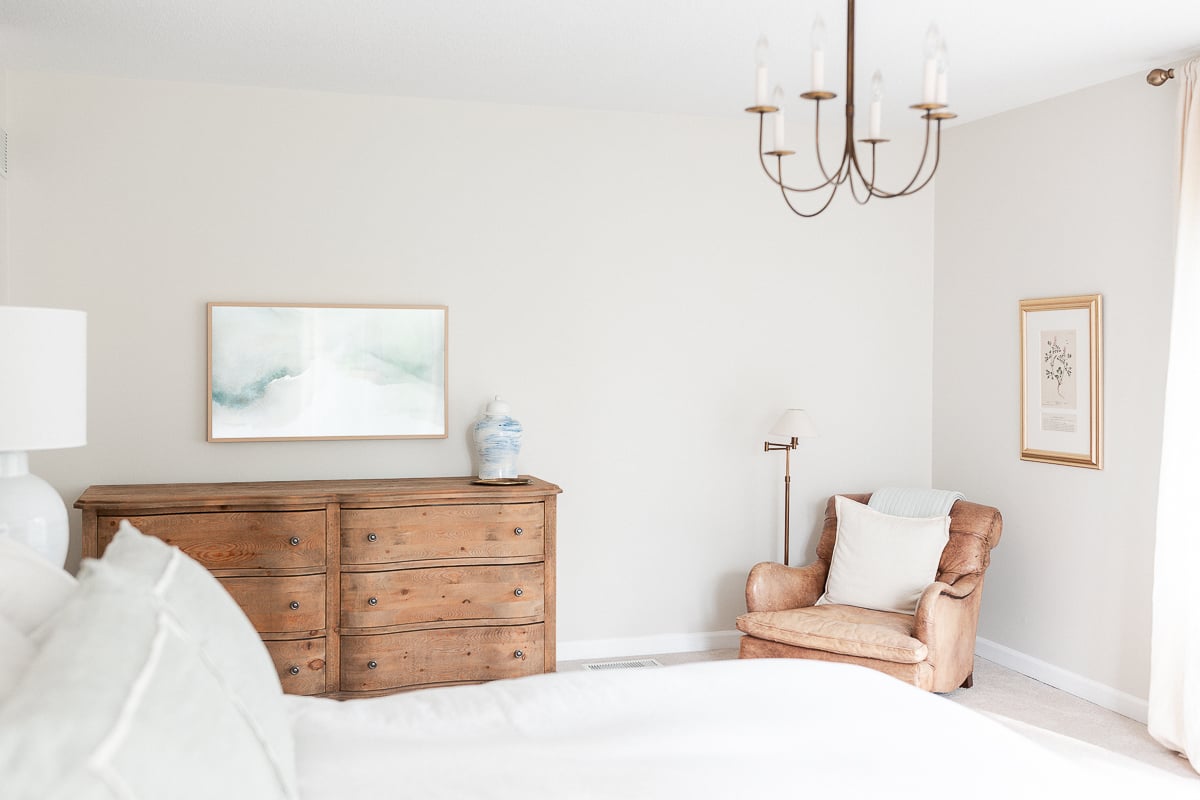 A primary bedroom in wood and cream tones with a minimalist design.