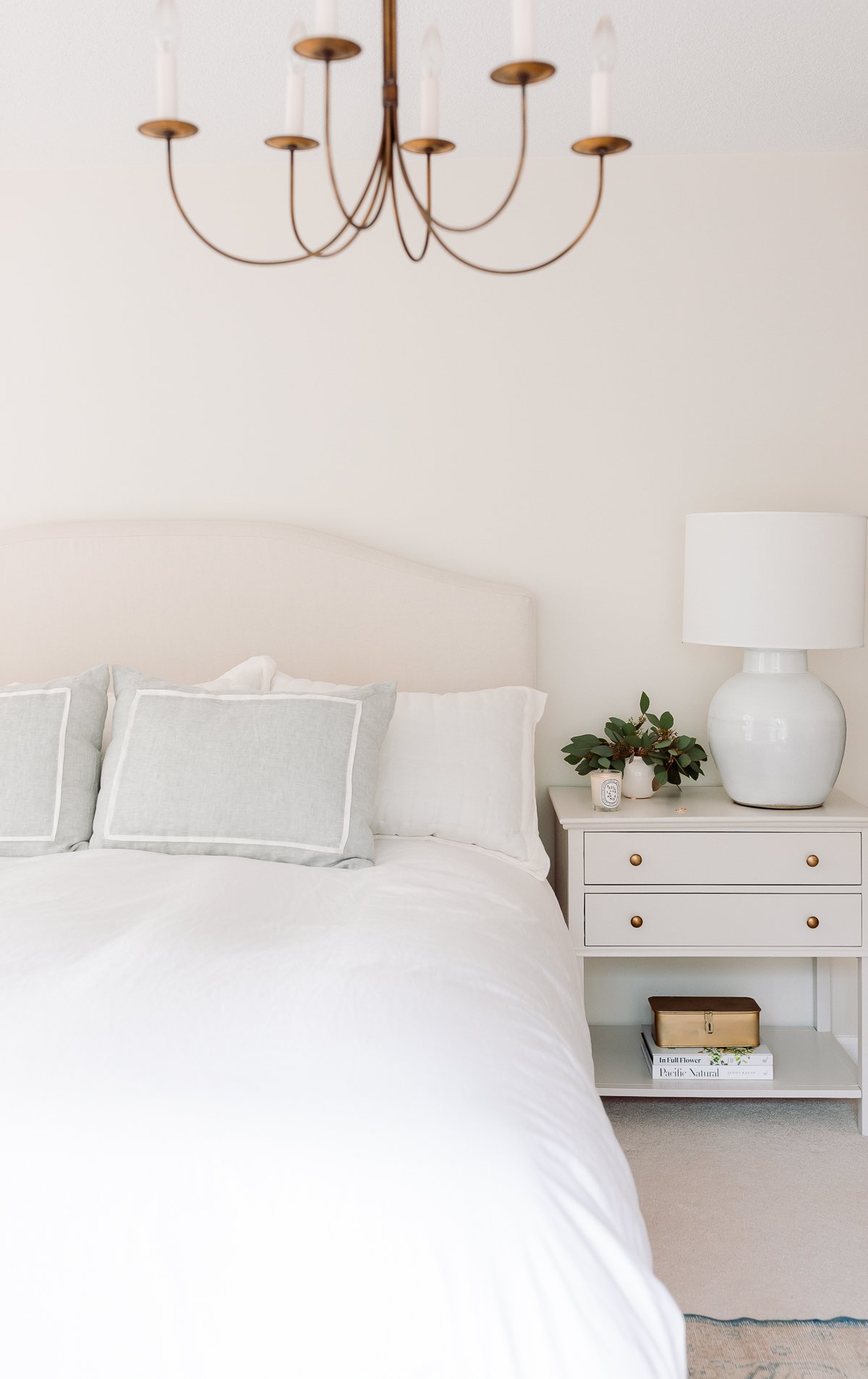 A primary bedroom in wood and cream tones with a minimalist design.